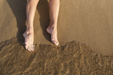 Female legs on sand