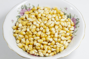 Close-up shots of multiple corn seeds in the small white cup