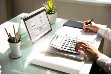 Businessman calculating invoice using calculator