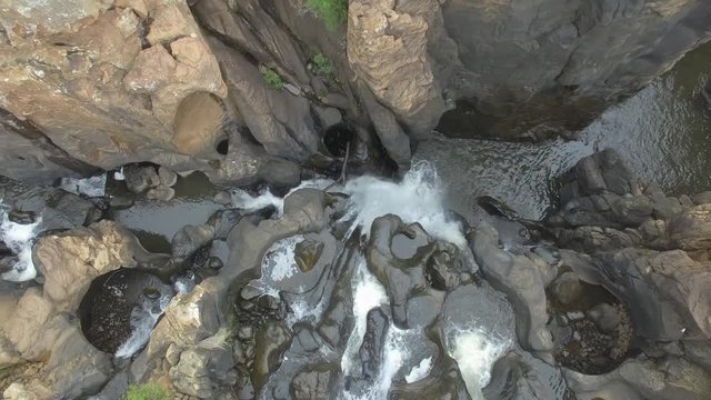 Straight Down Aerial Shot of a Waterfall at Bourkes Luck Potholes in South Africa, coming from the ground up in the air
