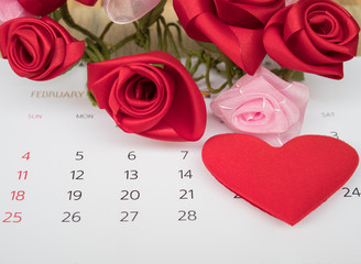 Red heart placed on calendar background.