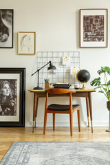 Art gallery in a retro home office interior with a desk and chair. Real photo