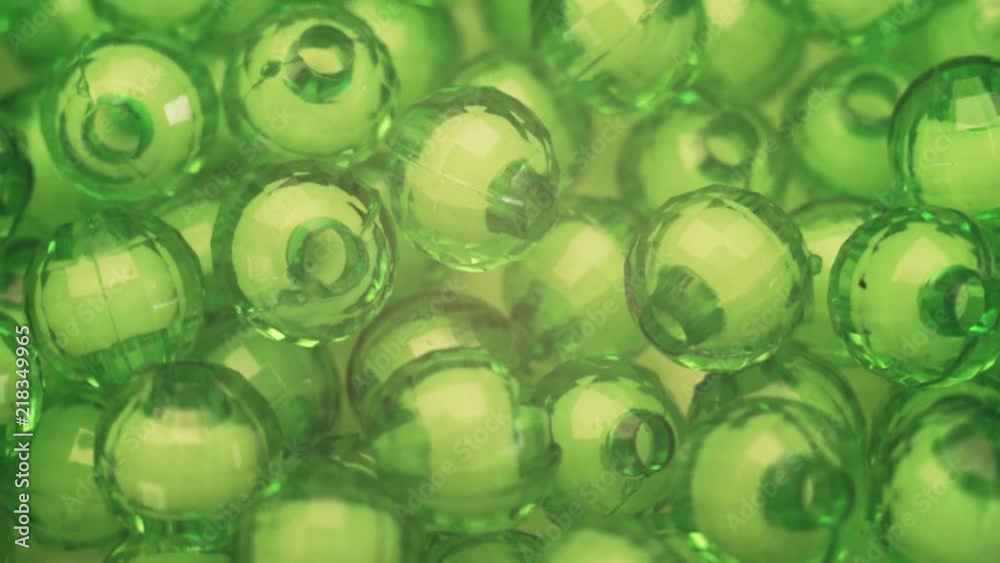 Poster green beads rotation background. macro view.