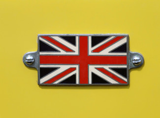 VA Vintage British Union Jack flag badge on a yellow car close up