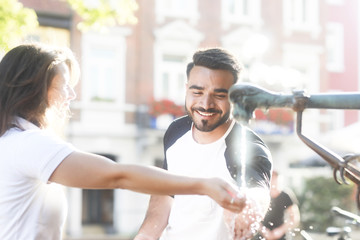 Junges Paar am Brunnen Wasser nehmend