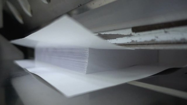 Paper cutting process, close-up, big industrial cutter for cutting paper shears - guillotine machine. Slow motion 250FPS