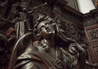 Angel with emotional expression or reflections, wooden statue in 12th century Saint Michael's church