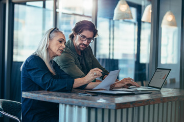 Colleagues talking over a business report