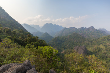 Fototapeta na wymiar Scenic view of lush mountains and hills near Vang Vieng in Laos on a sunny day.