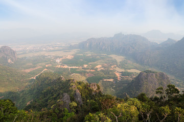Fototapeta premium Scenic view of Vang Vieng and the surrounding area from above from the Phangern (Pha Ngern, Pha ngeun) mountain in Laos on a sunny day.