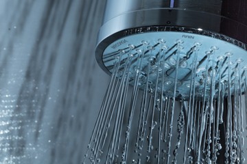 Naklejka na ściany i meble Shower Head with Water Stream on Grey Background