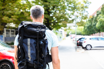 Rear View Of A Man Walking On Pavement