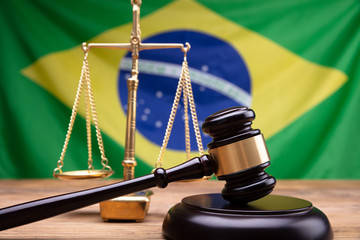 Wooden Mallet And Golden Justice Scale On Wooden Desk