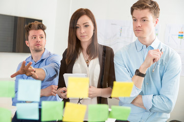 Businesswoman Looking At Strategies On Adhesive Notes By Colleag