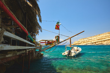 Matala beach with boat on clear sea