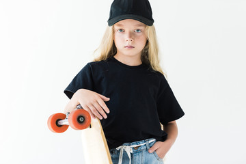 Child with long curly hair leaning at skateboard and looking at camera isolated on white © LIGHTFIELD STUDIOS
