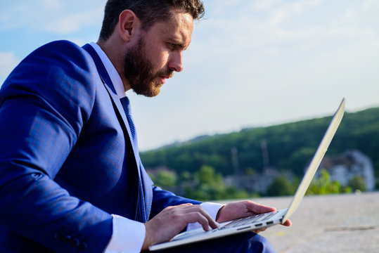 Internet marketing manager works blue sky background. Increase rates online sales tips. Businessman surfing internet or reply emails while sit with laptop outdoors. How get high reply rates