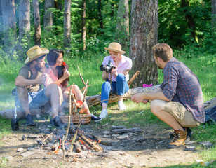 Naklejka na ściany i meble Tourists hikers sit on log relaxing waiting picnic snack. Company having hike picnic nature background. Picnic with friends in forest near bonfire. Hikers relaxing during snack time. Summer picnic