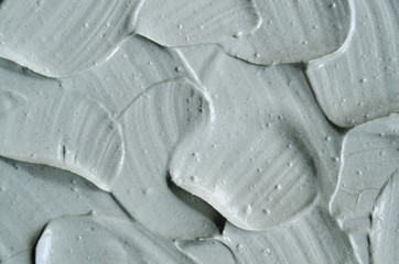 Gray cosmetic clay (kaolin) texture close up, selective focus. Abstract background with brush...