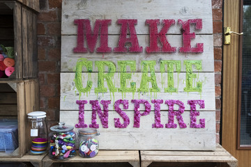 Handmade wooden sign with fabric letters in a workshop.
