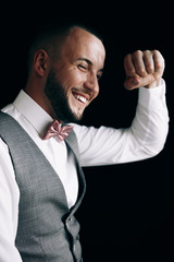 Guy on the black backdrop of smiles.A guy in a suit with bow tie