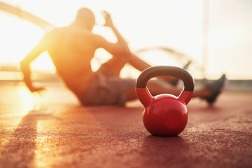 Kettle bell in focus, fitness training at early morning.