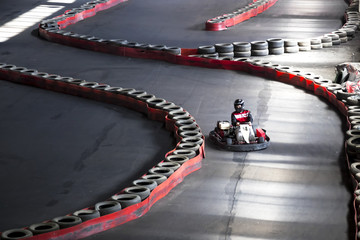 Riding on karting on the auto track. A young guy at the wheel of a carting.