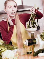 Woman in kitchen making vegetable smoothie juice