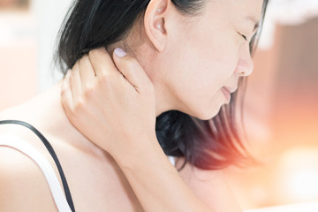 Naklejka premium Neck pain disease concept. Asian female hand on her neck as suffering from office syndrome neck ache
