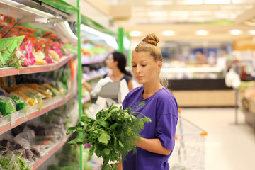Woman smelling lettuce in the supermarket