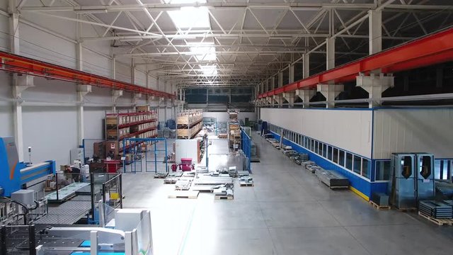 Inside the plant for the production of steel materials. Scene. Modern manufacturing storage with machine tools, roller conveyor, factory interior inside