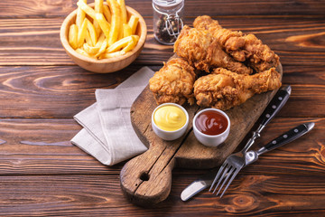 Crispy chicken legs and french fries potatoes. Fast junk food