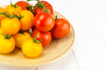 Ripe juicy tomatoes on large wooden plate