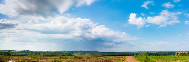 Fototapeta na wymiar Panorama of rapeseed field and road