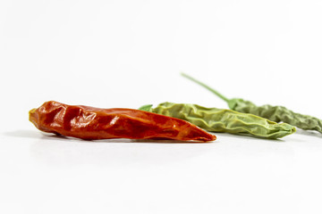 Cropped shoot of dried red and green colored peppers on white background