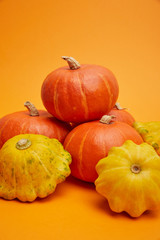 close-up view of pile of fresh raw ripe pumpkins on orange