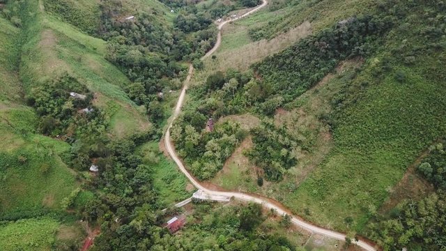 Flying over a rural area with dirt roads surrounded by small shacks here and there in Semuc Champey, Guatemala