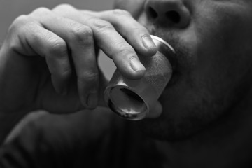 Drunk and unshaven male alcoholic finishes his vodka from the shot glass.