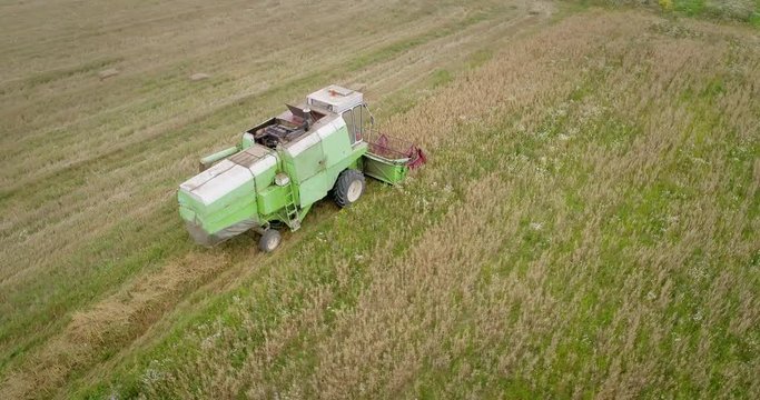 Aerial shot: An old chap combine harvester collecting ripe wheat