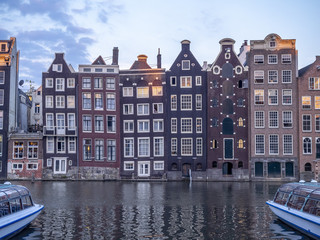 Historic buildings on the Damrak canal in the centre of beautiful Amsterdam at night.