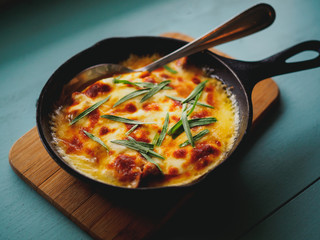 close up of homemade casserole with eggs and herbs in frying pan