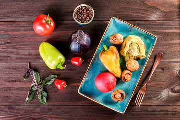 Grilled vagetables, mushrooms, tomatoes, eggplant on plate on wooden background. Healthy food