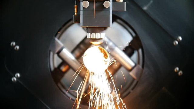 Cutting of metal, sparks fly from laser, modern tool in heavy industry.