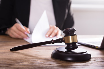 Close-up Of Gavel On Wooden Desk