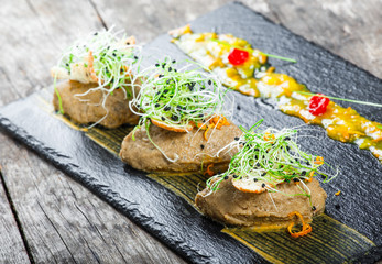 Appetizer from meat pate and onion on stone slate background on rustic table. Top view