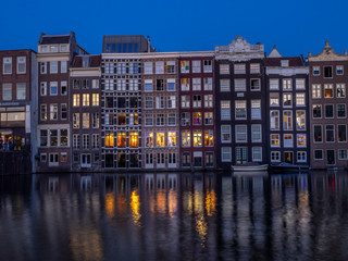 Obraz premium Historic buildings on the Damrak canal in the centre of beautiful Amsterdam at night.