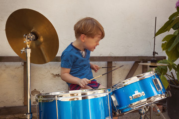 Little 3 year old boy playing drums