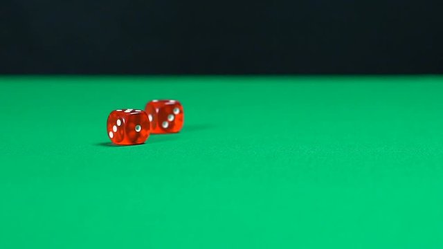 Red dice roll over casino table in slow motion, gambling background, games. Fortune, gambling, money