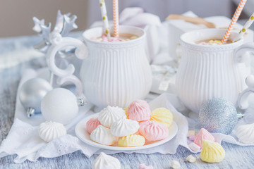 Cup of cacao with marshmallow, meringues and different Christmas decorations