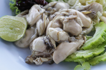 group of raw fresh pacific european big Oysters / Close up jelly animal at seafood restaurant, uncooked food unpearl oysters, delicious recipe menu with fresh vegetable and lemon